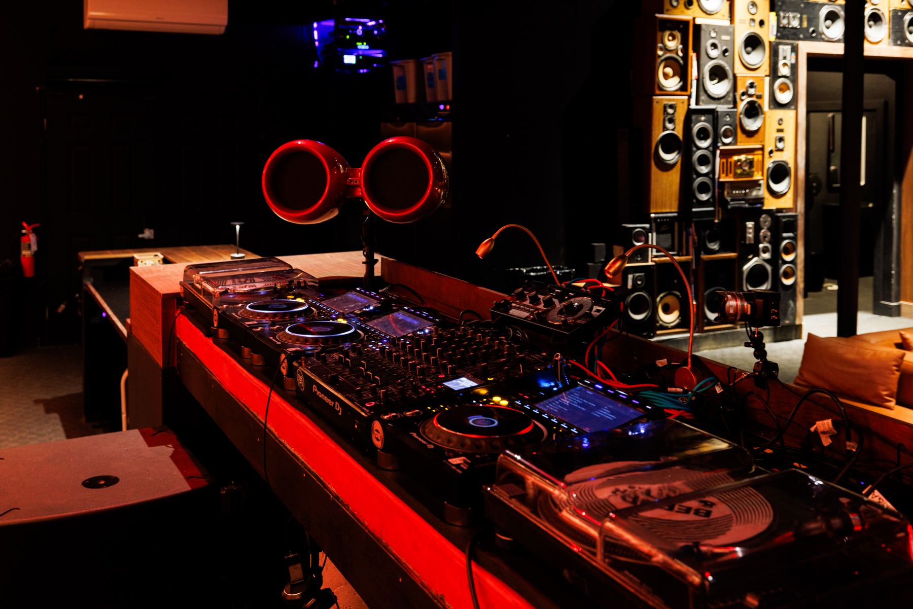Decks and mixer in the booth under red light